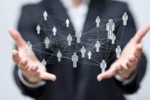 Profissional de RH segurando rede de pessoas, simbolizando os processos de RH. A rede foi feita com efeito digital na imagem