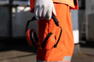 Profissional segurando EPI de ruído ocupacional (protetor auricular)