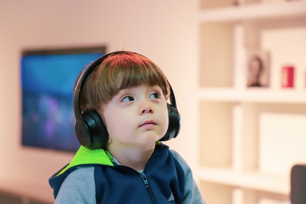 Exames audiológicos, criança com fone de ouvido durante exame