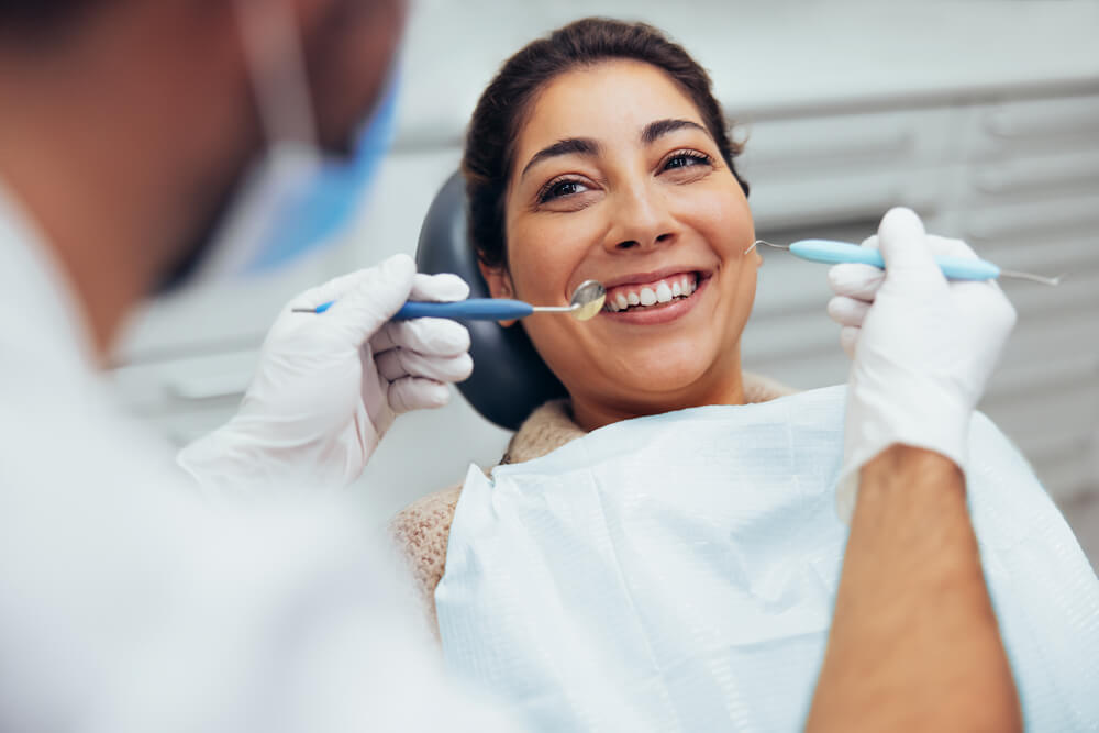 mulher sorrindo em consultório odontológico