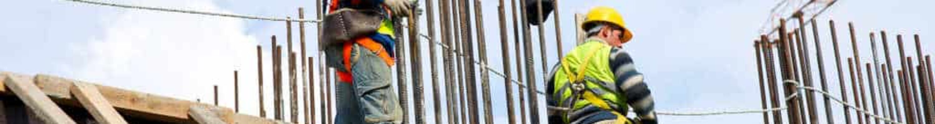 Dois pedreiros trabalhando em altura no telhado, simbolizando a dúvida sobre o que é e como calcular periculosidade